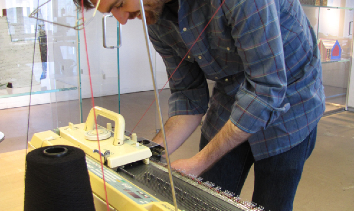 artist Andrew Salomone at work on his hacked knitting machine.
